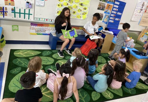 Two students read aloud to a group of younger students as part of Service Learning Day activities.