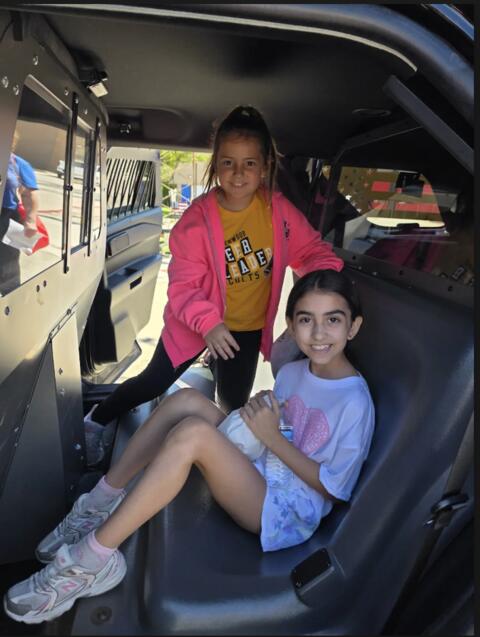 3rd graders in a police car