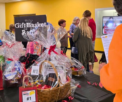Table Full of Raffle Baskets wrapped in cellophane