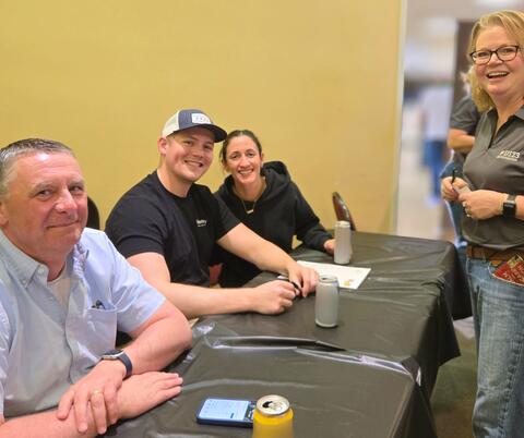 Volunteers at a Table Smiling
