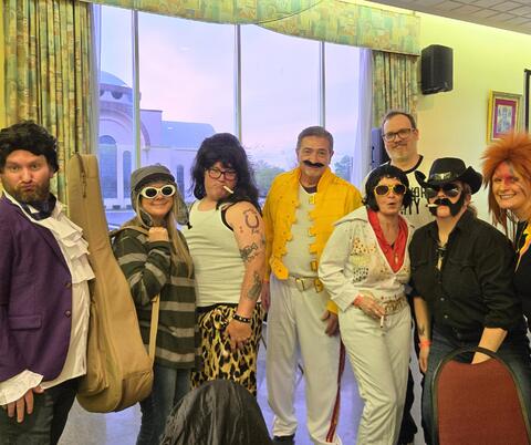 Group of trivia participants in musician-themed costumes.