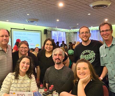 Table of trivia participants smiling for a group picture