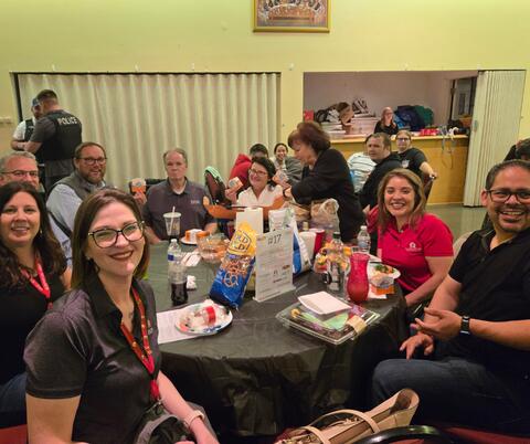Group at a table smiling at an indoor event