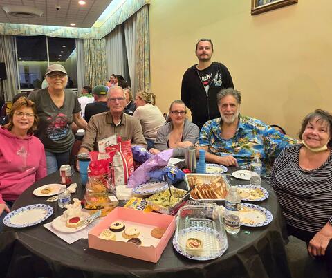 Group of people at a table with plates scattered around