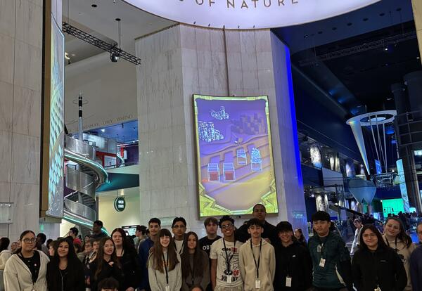 A groups of students smiling at the Museum of Science and Industry.