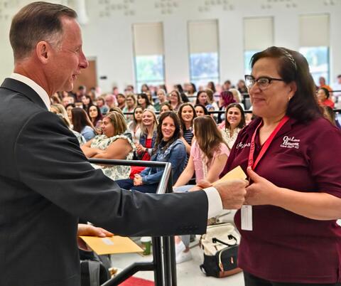 Staff member receiving recognition in front of cheering crowd