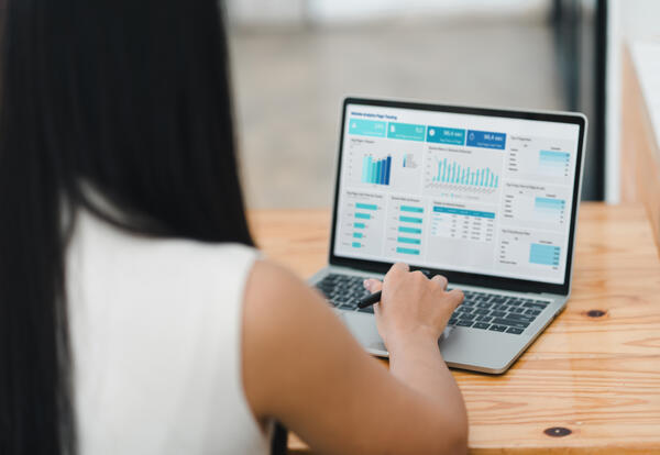 Looking over the shoulder of a woman that is previewing a data dashboard on her computer
