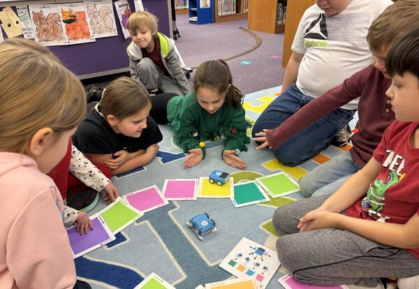 Here is a photo of students working in a group on a coding project
