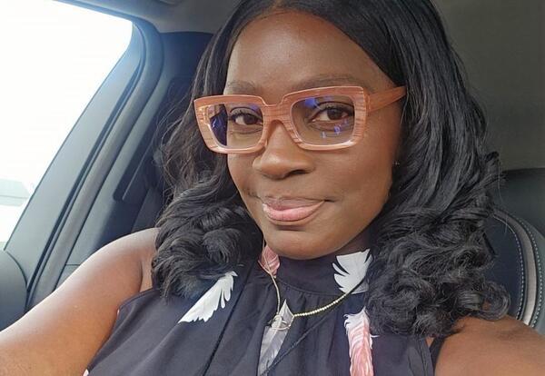 Woman smiling in car wearing glasses