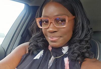 Woman smiling in car wearing glasses