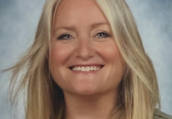 Woman smiling while wearing a necklace and green shirt