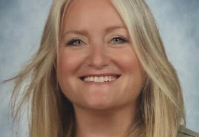 Woman smiling while wearing a necklace and green shirt
