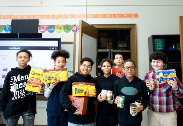 Boys smiling with donated canned goods