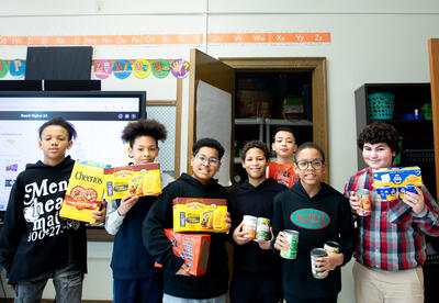 Boys smiling with donated canned goods