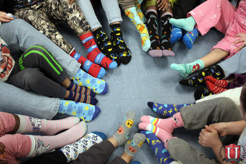 Students and staff show off socks in a circle