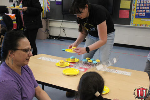 Staff grabbing cupcake from table