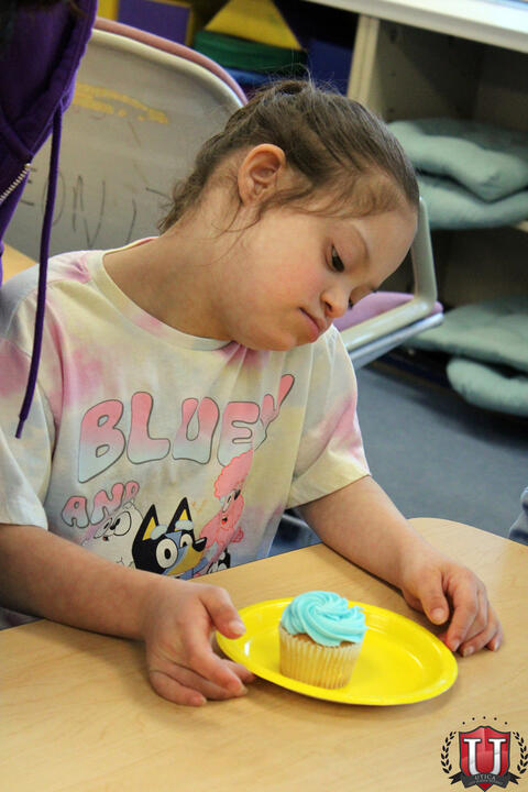 Student looking at cupcake on table