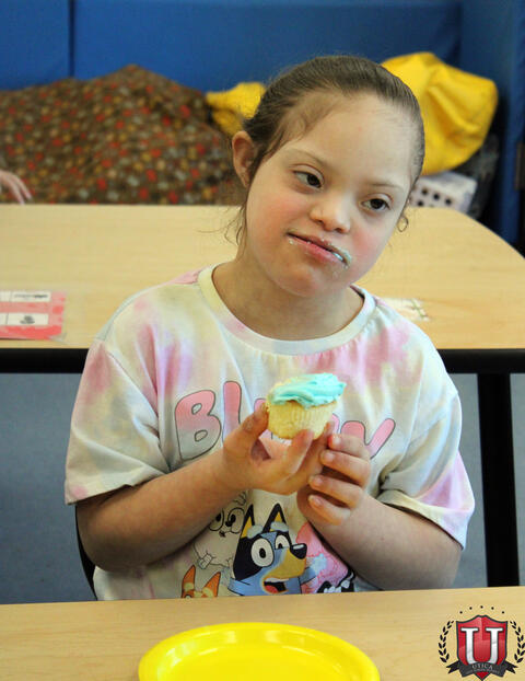 Student eats cupcake happily