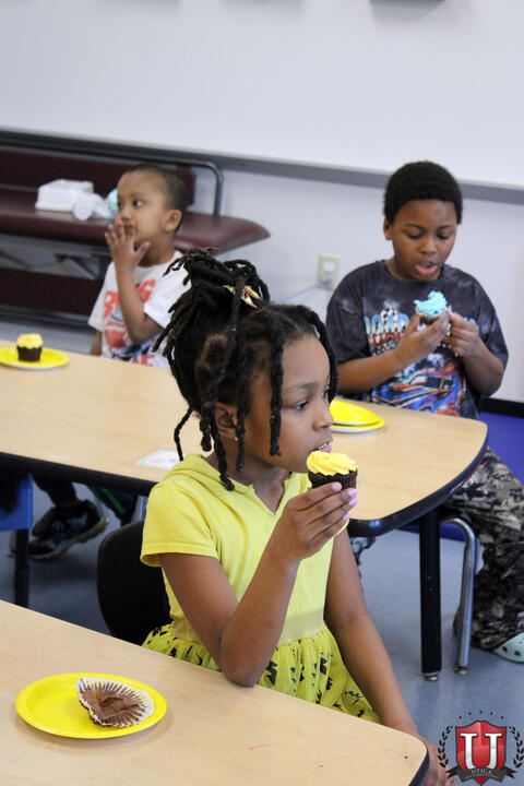 Group of Students eats cupcakes at table