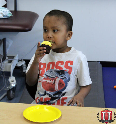 Student eats cupcake at table