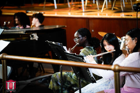 Students playing the flute while reading sheet music