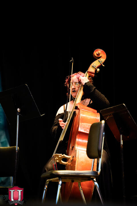Student playing large string instrument