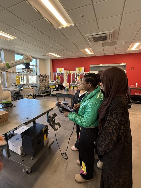 Student engaging with machinery curiously 