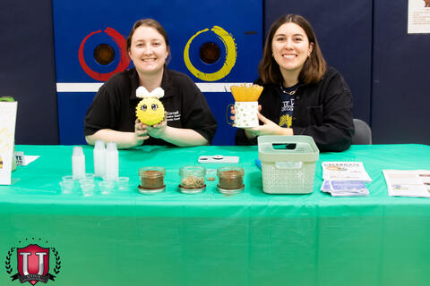 Staff smiling posing with plushie toy