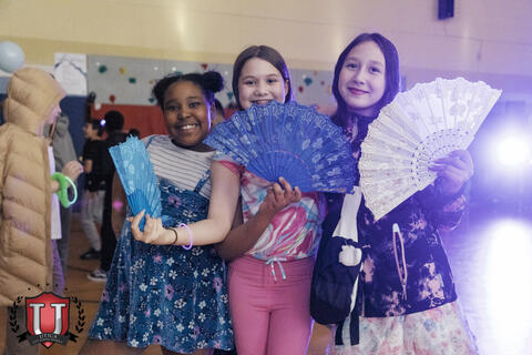 Students posing with fans happily