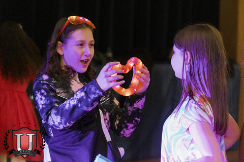 Student showing another student her glow up heart