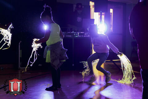 Students dancing crazy under black light lighting
