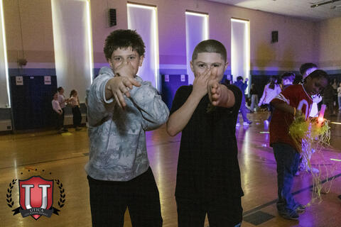 Two students posing and pointing at the camera