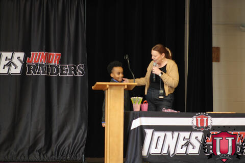 Student stands at podium to receive award