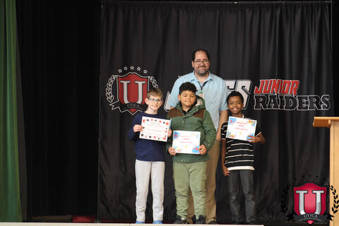 Three students pose together to celebrate their award