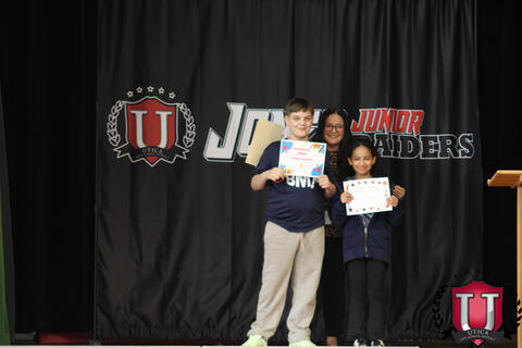 Students pose merrily as teacher lurks in back