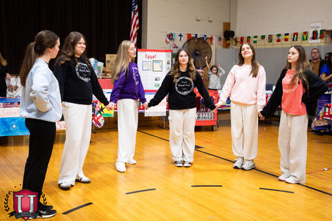 Students holding hands in a circle
