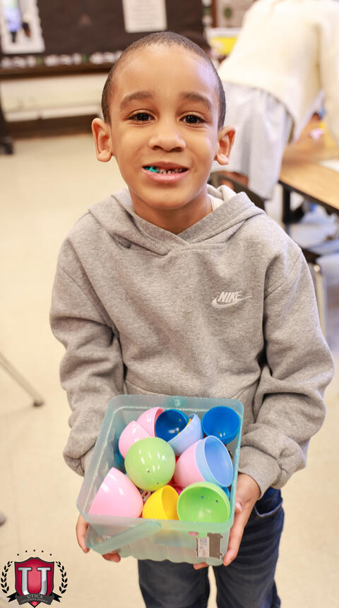 Student posing with eggs happy