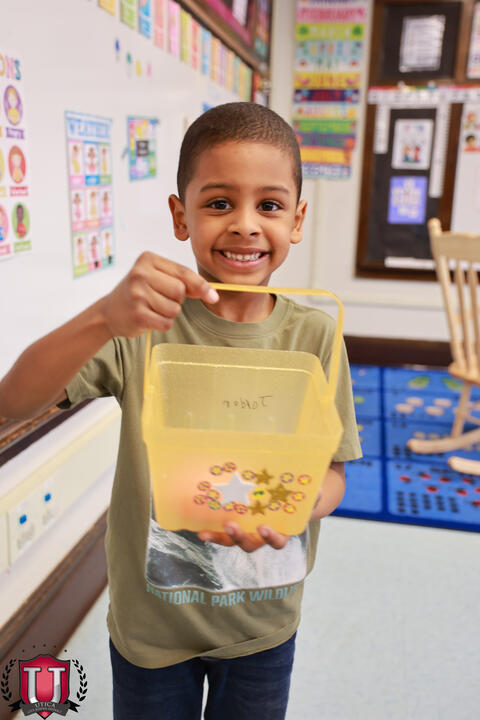 Student posing with a bucket of eggs