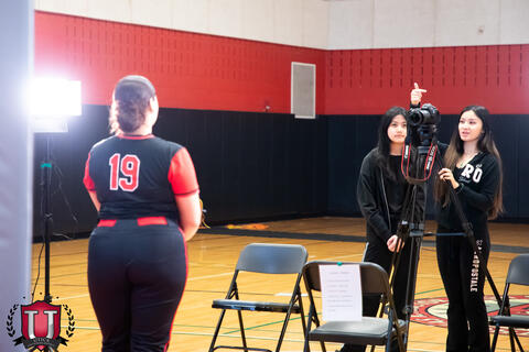 View from behind the set as a student gets their photo taken
