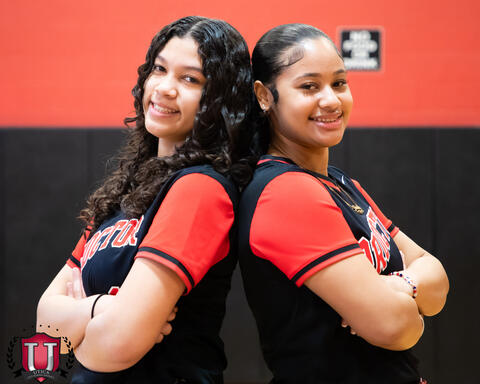 Students posing back to back smiling