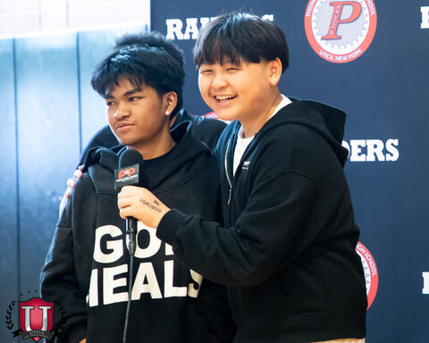 Student being interviewed by a another student laughing