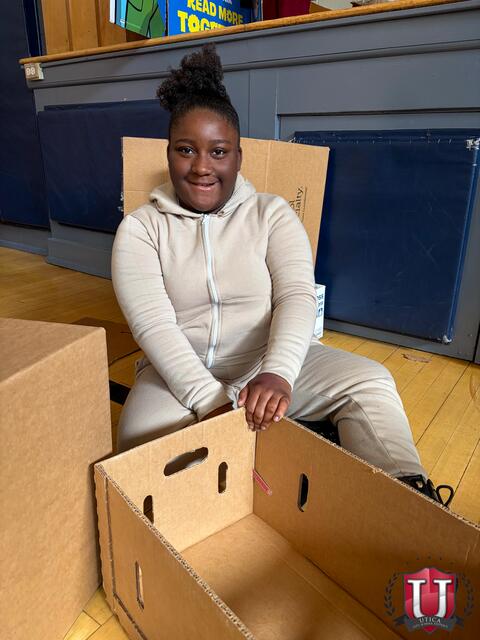 Student posing with their box