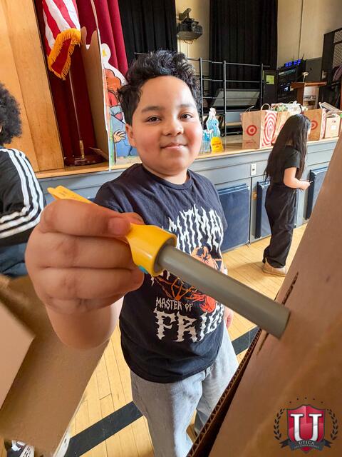 Student smiling while using their screwdriver