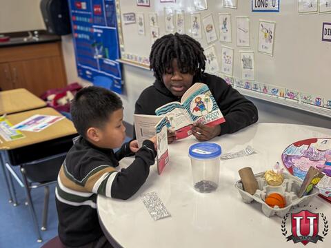 Students sitting at their table reading across from each other