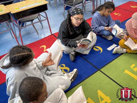 Students sitting in a circle on the carpet reading