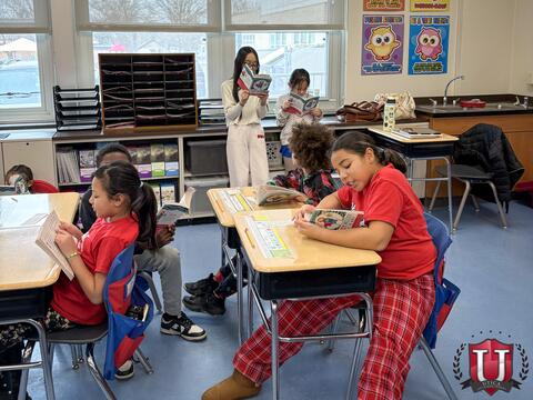 Room full of students reading and engaging with each other