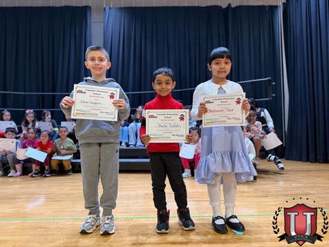 Three students on stage proud