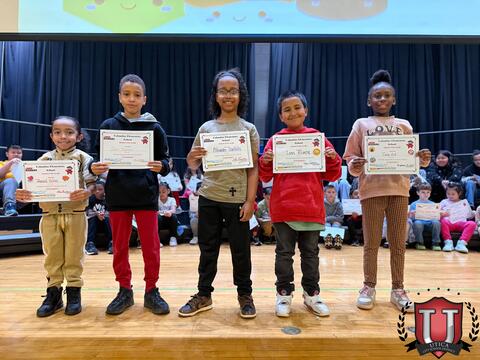 Five students proudly holding award