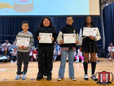 Four students holding award