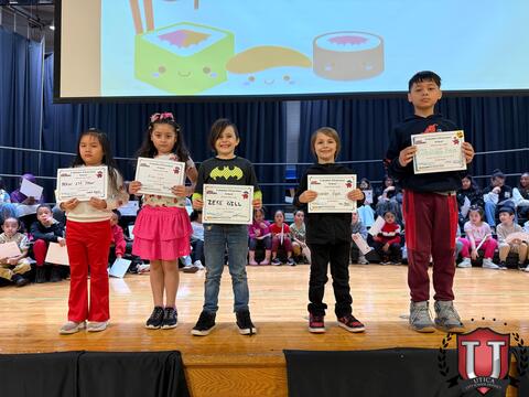 Small students posing with awards